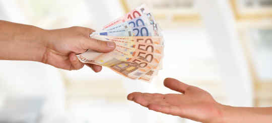 Zwei Hände tauschen Geld aus - symbolisch für die Abgabe des Pflichtteils im Erbrecht